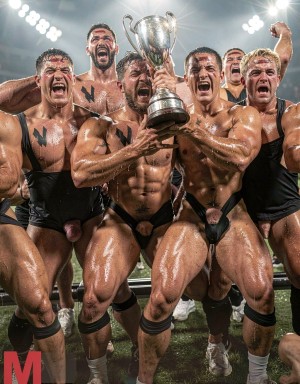 Un grupo de deportistas musculosos celebra eufórico en un campo embarrado bajo focos de estadio, empapados en sudor y barro mientras levantan una gran copa plateada como trofeo de campeonato. Visten singlets negros muy ajustados y parcialmente caídos, con el pecho descubierto, marcas oscuras pintadas sobre la piel y rodilleras o calcetines deportivos, creando una escena intensa de rugby, lucha o deporte de contacto. Sus expresiones son de gritos, victoria y adrenalina, con brazos tensos alrededor del trofeo y cuerpos brillantes por el agua. Algunos trajes dejan ver claramente el contorno del pene y la zona de la entrepierna, reforzando el aspecto crudo, físico y desinhibido de la celebración masculina.