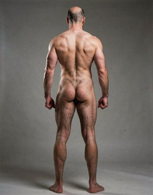 Mike Morris, a 32-year-old extremely lean Caucasian male at only 8% body fat, stands completely naked in a strict military attention pose seen from directly behind in a full posterior view. His back is perfectly straight, shoulders pulled back, arms rigid at his sides with fists clenched, legs straight and together, head held high. The shot captures him from the heels of his feet all the way up to the top of his bald head. His advanced Norwood III-IV baldness is clearly visible from behind, with a smooth tanned scalp on the crown and short dense dark brown hair only on the sides and lower back of the head. His back is highly defined and vascular: wide lats tapering dramatically to a very narrow, tight waist, thick trapezius muscles, and dense dark brown body hair lightly covering the shoulders and becoming much thicker and denser across the lower back and lumbar area, especially between the lats. His ass is tight, muscular and round with almost no fat, the glutes clearly separated. Thick dark hair continues down onto his powerful diamond-shaped calves and the backs of his slightly hairy feet. Dramatic directional studio lighting from above and slightly to the side creates strong highlights on his dry, shredded skin and deep shadows that accentuate every muscle fiber, the texture of his dense back hair, and the extreme vascularity and definition of his 8% body fat physique. Photorealistic, high-contrast, masculine 1970s Colt Studio aesthetic, grainy film texture, commanding and powerful presence. Las piernas están separadas 80 cm. La separación entre los pies es de ochenta centímetros. Se aprecia el surco entre glúteos  con una separación de glúteos de 4 cm.