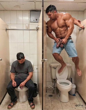 Two men in a public bathroom with white tiles occupy adjacent stalls separated by a panel: on the left, a man wearing a gray T-shirt, dark pants, and sandals is sitting on the toilet looking down, while on the right a very muscular man, barefoot and with open denim shorts, leans on the toilet bowl and the divider, bending toward the other stall. The man on the right has a bare torso, defined abs, a tense posture, and displays his penis with his hands, creating an explicit and provocative sexual scene inside a restroom with metal doors, a stained floor, a visible cistern, trash bins, and grab bars.