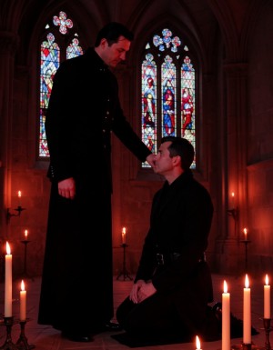 Escena de ritual gótico, figura dominante de pie detrás de hombre sumiso arrodillado, ambos vestidos con ropa oscura y elegante, sombras como de catedral, velas, luz ambiente roja, simbólico, cinematográfico, composición dramática, (ropa oscura:1.2) (elegante:1.1) (sombras:1.3), iluminación tenue, (velas:1.2) (luz roja:1.1), atmósfera misteriosa, (misterioso:1.2).

La figura dominante, un hombre alto y delgado con cabello negro y ojos intensos, viste un traje negro con cuello alto y botones de plata, (traje negro:1.2) (cabello negro:1.1), mientras que el hombre sumiso, de rodillas en el suelo, lleva una túnica negra con mangas largas y un cinturón de cuero, (túnica negra:1.2) (cinturón de cuero:1.1).

En el fondo, se ven arcos góticos y vitrales que filtran la luz roja, creando un ambiente sombrío y dramático, (arco gótico:1.2) (vitrales:1.1), mientras que en primer plano, las velas y la luz de las antorchas crean un efecto de iluminación dramático, (velas:1.2) (antorcha:1.1).

En el momento culminante del ritual, la figura dominante se inclina hacia adelante y susurra al oído del hombre sumiso: Con este beso, te reclamo, (beso:1.2) (reclamo:1.1), mientras que con esta mordida, te sello, (mordida:1.2) (sello:1.1), en un gesto que simboliza la sumisión y el dominio, (sumisión:1.2) (dominio:1.1).

Estilo barroco, (barroco:1.3), con detalles altamente realistas y una estética de fantasía oscura, (fantasía oscura:1.2), que evoca un mundo de misterio y poder, (misterio:1.2) (poder:1.1).