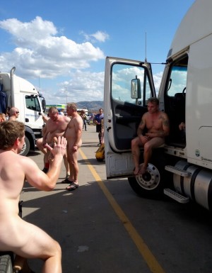 Lugar de cruising entre camiones,  varios hombres desnudos buscan camioneros,  algunos camioneros se asoman desde sus camiones sentados en la puerta delantera y con la puerta abierta,  enseñando sus penes erectos