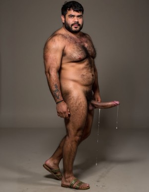 "Cocijo" es un hombre de "Zapoteca" es un señor gobernante del año año 600 d.C., en el cerro "La Cantera" de la localidad "San Pablo Huitzo" al norte del "Valle de Etla" en Oaxaca en México, está en la época antigua del periodo Clásico Tardío en México. 
Está muy delgado sin grasa en su cuerpo atlético y está totalmente desnudo y tiene sandalias de tiras. 
Tiene cara muy masculina con mandíbula cuadrada definida, cuello con tendones marcados, piel bronceada cubierta de una fina capa de sudor brillante.
Tiene torso con pectorales marcados y definidos en tensión con vello oscuro en el centro del pecho, pezones oscuros erectos, abdominales marcados de seis bloques visibles, tiene trail de vello desde el ombligo descendiendo hacia el pubis, tiene brazos con bíceps y tríceps muy marcados y definidos en tensión. 
Tiene piernas de cuádriceps marcados y definidos y tensos con los muslos peludos. 
Tiene una polla erecta y dura de treinta y cinco centímetros apuntando hacia arriba contra su abdomen goteando líquido preseminal blanco semitransparente, 
Tiene testículos grandes colgando pesados entre sus piernas. 
Tiene un tatuaje con texto escrito a la vista con las letras: "hipsterbarba". Plano lateral derecho