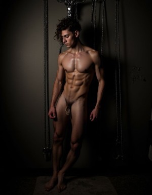 joven rubio desnudo de 25 años, de cuerpo muy delgado, sin vello en su cuerpo, pene pequeño. Esta encadenado en una jaula de metal en un sótano oscuro. Se ve su culo muy abierto para usar. Con suciedad a su alrededor y poca ilumincación. En la pared se ven cuerdas, cadenas, un látigo, hay una cruz de san andres para atar. Foto hiperrealista con su cuerpo marcado por sudor y esperma.