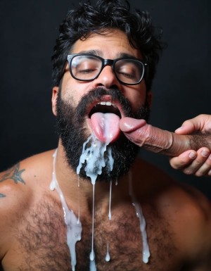 Hombre barbudo musculoso de 35 años arrodillado con cabeza echada hacia atrás, barba negra tupida empapada de semen blanco espeso, gafas de pasta negras salpicadas de leche, pelo negro despeinado, boca completamente abierta desbordando de esperma blanco cremoso cayendo en chorros gruesos, lengua extendida cubierta de lefa abundante, cara completamente bañada en semen con múltiples chorros blancos densos chorreando por frente mejillas nariz barbilla, ojos entrecerrados con lágrimas mezclándose con la corrida, gotas gruesas de esperma colgando de la barba y goteando al pecho peludo, torso desnudo bronceado salpicado de manchas blancas de leche, pectorales grandes peludos brillando con restos de corrida, mano masculina peluda visible sujetando polla enorme gruesa semierecta de 25cm justo delante de la boca expulsando los últimos chorros blancos espesos directamente sobre los labios abiertos, abundante semen acumulado en la lengua y desbordando por las comisuras, hilo grueso de lefa conectando el glande hinchado con la boca, expresión de satisfacción y sumisión, cuello tenso brillante de sudor y esperma, iluminación dramática cenital, fondo oscuro difuminado, plano medio frontal, fotografía hiperrealista 8K.

Ahí lo tienes, cabrón. Toda tu puta leche derramándose por mi cara y tragándomela como me has ordenado. ¿Satisfecho ahora o quieres verme aún más cubierto?