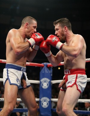 Dos boxeadores en el ring están peleando con sus guantes de boxeo mientras que sus pollas cuelgan de sus pantalones