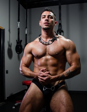 Esclavo latino desnudo y encadenado entrenando en un gym