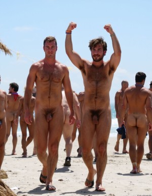 Solo hombres desnudos musculosos. Tienen un pene erecto de 50 cm de longitud y 8 cm de diámetro. Antonio tiene un pene erecto excitado de 50 cm de longitud y 8 cm de diámetro, también tiene el pelo largo movido por el viento. Juan tiene músculos muy definidos y tiene mucho vello corporal y es muy peludo, tiene un aro alrededor de la base de su pene y de los testículos. Tienen sandalias en sus pies. Flexionan sus brazos hacia arriba para enseñar sus músculos bíceps. Fondo de una playa con un mar precioso. Fondo de muchos hombres desnudos caminando y mirando a Antonio y a Juan.