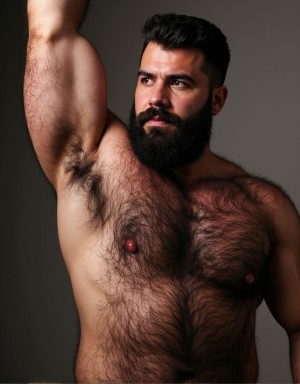Hombre de torso desnudo con complexión robusta y pecho muy velludo, posando de pie sobre un fondo gris oscuro con iluminación de estudio que resalta el volumen del cuerpo y la textura del vello corporal. Tiene un brazo levantado por encima de la cabeza, dejando visible la axila con pelo, mientras gira ligeramente la mirada hacia un lado con expresión seria e intensa. Su barba negra, espesa y bien cuidada, junto con el pelo corto peinado hacia arriba, refuerza una apariencia masculina y segura. La piel aparece cálida bajo la luz lateral, destacando los pectorales, el abdomen, los pezones y el contorno del hombro y el brazo.