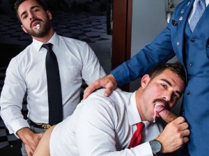 El nuevo empleado bancario le mama el rabo al jefe de la sucursal, que eyacula en su boca, mientras tanto,  otro empleado lo penetra analmente, una secretaria grita al ver la escena, van todos con traje y corbata, aunque se han quitado las chaquetas. Ambientado en una sucursal bancaria