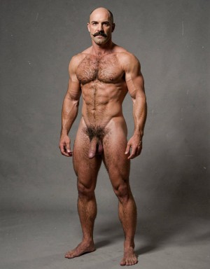 Mike Morris, a 32-year-old extremely lean Caucasian male with only 8% body fat, stands completely naked in a strict military attention pose captured in a full-body three-quarter view at a slight 45-degree angle. The shot runs from the tips of his size 44 slightly hairy feet all the way up to the top of his bald head, showing his entire body without any cropping. His physique is dry, vascular and powerfully defined: massive square pectorals covered in dense dark brown chest hair forming a thick T-pattern, sharply carved six-pack abs, narrow waist, wide flaring lats, and thick muscular thighs with dense dark hair. Dramatic directional studio lighting falls from high and slightly to the left, creating bright highlights on his tanned skin, the texture of his dense body hair across his chest, lower back and legs, and deep shadows that accentuate every muscle separation and vein. His advanced Norwood III-IV bald scalp is clearly visible, with short dense dark brown hair only on the sides and back of his head. His square, angular face with prominent jaw, thick dark handlebar mustache, heavy brows and intense deep-set brown eyes stares straight ahead with a serious, commanding expression. His penis is fully visible, completely natural and realistic: thick, 24 cm long when erect, with natural upward curve, prominent veins along the shaft, long foreskin that partially covers the pink-red glans, and realistic skin texture noticeably lighter than his bronzed body. Below it hang his large, low-hanging testicles with wrinkled darker skin and dense dark brown hair. The extremely thick, curly dark brown pubic bush climbs almost to his navel and spreads generously around the base of his cock and balls. Every detail from his veined hands and forearms to his diamond calves and hairy toes is perfectly proportioned and anatomically correct. Photorealistic, high-contrast, masculine 1970s Colt Studio aesthetic with subtle grainy film texture.