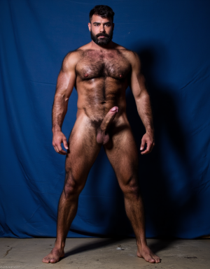 Enomao. Hombre de 35 años, cuerpo completo de pies a cabeza, pose frontal de pie, cuerpo delgado, rostro rudo con mandíbula cuadrada y ceño fruncido, barba abundante negra descuidada de varios días, nariz ancha, cicatriz pequeña en la ceja izquierda, mirada intimidante, pelo negro largo y despeinado, cuello grueso con tendones marcados, hombros anchos y trapecios abultados, pectorales enormes y duros con sombras profundas bajo cada músculo, pezones oscuros rodeados de vello negro denso, vello negro abundante cubriendo todo el pecho extendiéndose hacia el abdomen, abdominales definidos con seis bloques marcados y venas visibles, línea de vello negro desde el ombligo bajando, oblicuos duros con sombras que acentúan cada fibra muscular, brazos con bíceps y tríceps marcados y muy definidos, venas prominentes en los antebrazos, vello negro espeso en antebrazos y dorso de las manos, manos con nudillos anchos y dedos fuertes, piel con suciedad natural como grasa de trabajo y tierra en pecho brazos y piernas, manchas de mugre en los antebrazos y marcas de sudor seco, muslos marcados con cuádriceps separados y definidos cubiertos de vello negro abundante, pantorrillas duras en tensión con vello oscuro, pies descalzos plantados en suelo de hormigón, iluminación lateral dura que proyecta sombras profundas en cada grupo muscular resaltando la masa y la fuerza bruta, ambiente de atmósfera cruda y masculina, fotografía hiperrealista, textura de piel visible con poros y imperfecciones. Tiene un pene erecto masculino de 38,5 cm de longitud y 8,5 cm de diámetro, proporciones perfectas, glande grueso y pronunciado con corona marcada, color rosado oscuro en la cabeza contrastando con el tono bronceado del tronco, venas gruesas y ramificadas recorriendo toda la extensión del falo desde la base hasta el glande, piel tensa y brillante por la erección máxima, prepucio retraído mostrando el frenillo, testículos grandes y pesados colgando en escroto arrugado, cubiertos de vello púbico oscuro y denso, pelo rizado extendiéndose hacia la base del pene, piel escrotal con textura visible y poros definidos, venas visibles en los testículos, posición frontal ligeramente angular, pene erecto, mano derecha rodea el pene para masturbación, eyaculación y grito de orgasmo, iluminación de estudio con sombras suaves que resaltan cada relieve y textura, fotografía hiperrealista, ultra alta definición 4K, texturas extremadamente detalladas, colores naturales de piel humana, acabado cinematográfico.

El fondo de la imagen es un azul ultramar intenso y profundo, con ondas de tela que ondean como si fueran arrastradas por el viento, creando un movimiento dinámico con la figura. La textura ondulante, similar a la seda, añade una capa de profundidad y sensibilidad a la escena, contrastando con la crudeza y pasión del acto sexual.

La fotografía realista, con genitales anatómicamente correctos y proporciones naturales, sin distorsión, busca capturar la esencia cruda y visceral del momento, sin adornos ni censuras. El enfoque en el punto del pene visible desde un ángulo lateral, busca resaltar la intensidad y la conexión del hombre y su entorno, inmerso en un acto de pasión y deseo. El contenido explícito para adultos es una representación auténtica y sin tapujos de la intimidad y el deseo humano, sin rodeos ni evasivas. Es un hombre lobo