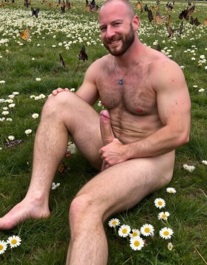 hombre culturista de 35 años posando desnudo de cuerpo completo, sonriente, tensa los bíceps, tiene un pene de 40 cm de longitud y 7 cm de diámetro, tiene grandes dorsales, piernas, tiene cintura estrecha, es un poco calvo, tiene grandes pezones rosas. Tiene un pene de 40 cm de longitud y 7 cm de diámetro. Tiene mucho vello en pecho y brazos y piernas. Tiene testículos de 10 cm de diámetro que están colgando y se mueven al compás de los movimientos del cuerpo. Tiene pies con sus uñas pintadas de color rojo. Fondo de muchas margaritas de todos los colores y miles de mariposas volando. Tiene el cuerpo bronceado por el Sol. Está en la hierva rodeado de margaritas. Está sentado y quiere enseñar su ano. Tiene el ano relajado y abierto y a la vista del espectador. Por su pene erecto. Con su mano derecha rodea su pene por su perímetro acariciando el pene con suavidad. Tiene un gran pene erecto y lleva piercings de pezón en los pezones.  (respeta la forma y la proporción del cuerpo y sé fiel a la forma real de los cuerpos, sin distorsiones) (+10)