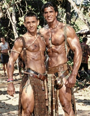 Años 60. Dos actores de Hollywood, musculosos y bien caracterizados,  posan mostrando su pecho musculoso para la cámara en un descanso del rodaje de un western. 