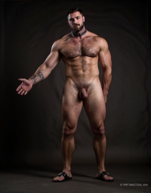 Austin Wolf, 40 años, 1.88m de altura, musculoso, cuerpo extremadamente marcado y definido, pectorales grandes y cuadrados, abdominales six-pack profundos, brazos gruesos y venosos, hombros anchos, trapecios marcados, piel blanca bronceada, pelo negro corto con rapado a los lados estilo fade, barba negra densa perfectamente recortada cubriendo mandíbula cuadrada, ojos marrones oscuros con mirada penetrante desafiante, rasgos faciales masculinos y angulosos, nariz recta, cejas gruesas, vello corporal negro medio en pecho bajando por abdomen, tatuajes en brazos y torso, manos atadas detrás de la espalda con cuerdas gruesas negras, collar de cuero negro con argolla de metal plateado al cuello, torso desnudo brillante de sudor con marcas de latigazos cruzando la espalda y hombros, expresión de sumisión forzada pero con actitud alfa contenida, mandíbula apretada, músculos tensos y flexionados, piernas musculosas muslos mostrando pene grande pronunciado, tiene pene de 20 cm de longitud y 8 cm de diámetro. Tiene sandalias negras en los pies. Iluminación dramática cenital tipo mazmorra BDSM, cadenas y ganchos colgando del techo de fondo, ambiente oscuro con tonos grises y negros, fotografía hiperrealista 8K. Tiene zapatos de tacón alto de color negro en los pies. Sus pies están a la vista. Está muy contento de su cuerpo perfecto y levanta y flexiona los brazos para enseñar sus músculos bíceps. Está muy contento de tener el cuerpo perfecto que gusta a todos. Enseña sus pies. Salta de alegría enseñando su pene de 18 cm de longitud con una sonrisa de alegría por tener un cuerpo perfecto. Manos arriba brazos hacia arriba flexionados enseñando músculos bíceps muy marcados. Yo (hombre muy fuerte) estoy en su espalda con mis manos sobre sus pectorales peyizcando sus pezones hasta hacerle eyacular