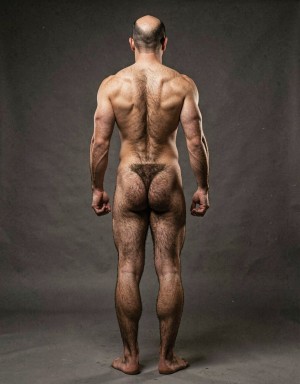 Mike Morris, a 32-year-old extremely lean Caucasian male at only 8% body fat, stands completely naked in a strict military attention pose seen from directly behind in a full posterior view. His back is perfectly straight, shoulders pulled back, arms rigid at his sides with fists clenched, legs straight and together, head held high. The shot captures him from the heels of his feet all the way up to the top of his bald head. His advanced Norwood III-IV baldness is clearly visible from behind, with a smooth tanned scalp on the crown and short dense dark brown hair only on the sides and lower back of the head. His back is highly defined and vascular: wide lats tapering dramatically to a very narrow, tight waist, thick trapezius muscles, and dense dark brown body hair lightly covering the shoulders and becoming much thicker and denser across the lower back and lumbar area, especially between the lats. His ass is tight, muscular and round with almost no fat, the glutes clearly separated. Thick dark hair continues down onto his powerful diamond-shaped calves and the backs of his slightly hairy feet. Dramatic directional studio lighting from above and slightly to the side creates strong highlights on his dry, shredded skin and deep shadows that accentuate every muscle fiber, the texture of his dense back hair, and the extreme vascularity and definition of his 8% body fat physique. Photorealistic, high-contrast, masculine 1970s Colt Studio aesthetic, grainy film texture, commanding and powerful presence.