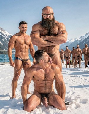 hyperrealistic cinematic photograph, bright sunny winter day at Lake Louise with turquoise water and snow-capped Rocky Mountains in the background, snowy path with a crowd of naked men watching silently from a distance. Hipsterbarba stands completely dominant in the center, 40 years old, 180cm, 80kg, 8% bodyfat, powerful muscular bear physique covered in dense dark body hair across chest, shoulders, abs and thighs, extremely long thick Bandholz beard reaching almost to his chest, curled handlebar mustache, black glasses, small tattoo “hipsterbarba” on right bicep, arms crossed over his hairy chest, cold superior expression, looking down. Directly in front of him, Ferran is on his knees in the snow, 30 years old, peak competition physique at 5% bodyfat, massive separated pecs, razor sharp six-pack, narrow waist, highly vascular arms, dark chest hair between pecs and thick pubis, square jaw, modern fade haircut, prominent curled handlebar mustache, thick heavy cock hanging low between his muscular hairy thighs. Ferran has his face pressed close to Hipsterbarba’s crotch, tongue fully extended licking his heavy hairy balls with careful slow strokes, eyes looking up in submission. To the left side stands Anil, 25 years old, extreme bodybuilder slave, 175cm, 80kg, 6% bodyfat, massive 127cm chest, sharp eight-pack, narrow 60cm waist, dramatic V-taper, completely smooth skin from the neck down, thick semi-erect cock pulled forward and dripping long strings of precum due to the tight metal cock ring at the base, small tattoo “Hipsterbarba mi amo” on right bicep, head bowed in total submission, trembling slightly. Sharp sunlight creating dramatic shadows that highlight every muscle, vein, body hair, sweat droplets and the wet shine of Ferran’s tongue on the balls. Perfect anatomy and proportions, zero distortions.