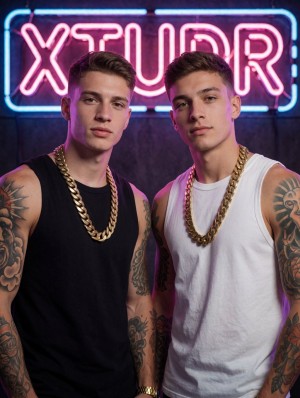 Dos hombres jóvenes posan de frente con expresión seria y segura ante un fondo oscuro iluminado por un rótulo de neón rosa y azul que destaca la palabra “XTUDR”. Ambos llevan camisetas sin mangas que dejan visibles sus brazos musculados y tatuados: el de la izquierda viste una camiseta negra, luce una cadena dorada gruesa y tiene tatuajes grandes en el brazo, incluido un diseño tipo león; el de la derecha lleva camiseta blanca, una cadena dorada similar y tatuajes tribales y figurativos en hombros y antebrazos. La iluminación de estudio mezcla tonos magenta y azul, creando una estética urbana, nocturna y llamativa, con estilo de moda callejera, joyería dorada, tatuajes y actitud de sesión fotográfica promocional.