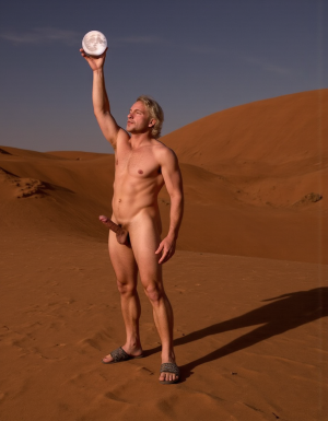 Enrique es un hombre muy delgado de 50 años, tiene cabello largo con canas blancas, tiene barba blanca abundante y larga. Está totalmente desnudo, en su mano derecha lleva una bola de 10 cm de diámetro de cristal, es mágica y está iluminada reflejando la  cara de un hombre desnudo con un pene erecto con dos testículos peludos, eleva la bola hacia el cielo ofreciéndola a la Luna. Enrique tiene un cuerpo muy delgado con músculos marcados y definidos. 💪🏼. Tiene un pene erecto de 36,8 cm de longitud y 7,9 cm de diámetro. Tiene mucho vello corporal blanco en su pecho, tiene mucho vello en sus brazos y tiene mucho vello en sus piernas. Está en la arena del desierto entre grandes dunas de arena color terracota. Tiene la piel morena bronceada por el Sol. Tiene sandalias en sus pies. Está mirando a la Luna mientras levanta la palma de la mano derecha señalando la Luna 🌓 . Tiene la boca entreabierta. Tiene la mano derecha sobre su pene y está masturbándose 