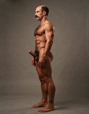 Mike Morris, a 32-year-old extremely lean Caucasian male with only 8% body fat, stands completely naked in a rigid military attention pose captured in a full-body exact side profile at 90 degrees from his right side. The shot runs uninterrupted from the tips of his size 44 slightly hairy feet all the way up to the top of his bald head, showing his entire body without any cropping whatsoever. His physique is dry, highly vascular and powerfully defined: massive square pectorals seen in perfect side silhouette, dense dark brown chest hair forming a thick T-pattern that continues across his shoulders and back, sharply carved six-pack abs in clear profile, narrow waist, wide flaring lats, powerful thighs and diamond-shaped calves covered in the same dark hair. Dramatic directional studio lighting falls from high and slightly in front of him, creating strong rim lighting that traces every sharp edge of his muscular outline, accentuating the texture of his dense dark body hair on chest, shoulders, lower back, ass and legs, while producing deep shadows that highlight every muscle separation, vein and the extreme dryness of his 8% body fat. His advanced Norwood III-IV bald scalp is clearly visible under the light, with very short dense dark brown hair only on the sides and back of his head. His square, angular face is shown in pure right profile: strong jawline, prominent chin with slight central dimple, thick well-groomed dark handlebar mustache, heavy brow and intense deep-set brown eye staring straight forward with a serious, commanding expression. His penis is fully and clearly visible in perfect side view, completely natural and anatomically correct: thick, 24 cm long when fully erect, with a natural slight upward curve, prominent dorsal veins running along the shaft, long foreskin that partially covers the pink-red glans, and noticeably lighter skin tone than the rest of his bronzed body. Below it hang his large, low-hanging testicles with wrinkled darker skin and an extremely dense, curly dark brown pubic bush that climbs almost to his navel and surrounds the base of his cock and balls generously. Every detail from his veined hands and forearms to his muscular ass, hamstrings, diamond calves and hairy toes is perfectly proportioned and free of any deformation. Photorealistic, high-contrast, masculine 1970s Colt Studio aesthetic with subtle grainy film texture.