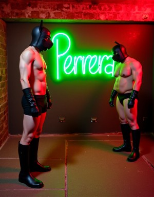 4 jovenes delgados de 25 años con mascara de puppy de color negro, completamente desnudos a 4 patas, con plug de cola de perro de silicona. Estan en un sotano con el suelo de piedra y paredes de ladrillo. La sala está iluminada con luces rojas, y detrás un enorme neon verde que pone "Perrera". De pie hay un maduro de 60 años de cuerpo fuerte y musculoso, casi desnudo, solo lleva un slip de cuero negro abultado y unas botas altas negras de cuero que los mira con vicio