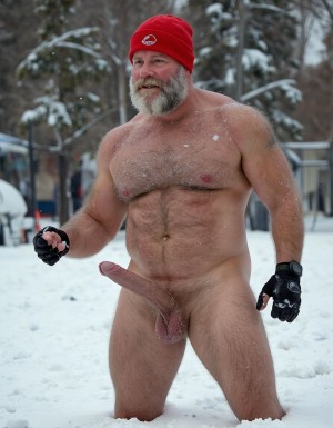 La Navidad. Papá Noel es un hombre de 40 años, atleta, está delgado y tiene músculos marcados y definidos, es muy varonil, tiene barba blanca abundante. Solo tiene el gorro de papá Noel porque está totalmente desnudo enseñando su musculatura de atleta y bronceada, tiene mucho vello blanco que cubre sus músculos pectorales y el abdomen y también en sus piernas. Tiene sandalias blancas en sus pies. Barba abundante blanca de papá Noel. Es el Papá Noel del año 2025, con mucha alegría y mucho sexo gay. Aspecto muy masculino salvaje. Pene erecto de 20cm de longitud y 8cm de diámetro. Abundante vello blanco por todo el cuerpo. Está saltando sobre la nieve mientras nieva y su gran pene erecto de 22 cm de longitud y 9 cm de diámetro se llena de nieve. Está masturbando su pene con la mano derecha.