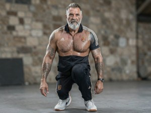 Hazme la imagen de un dady, con un chandal adidas chile, sin camiseta, musculado, con bello corporal, el color del pelo que sea canoso, peinado un tupe con degradado, barba blanca a pico,unas zapatillas nike tn, que tenga abdominales, ponle tatuajes, hazlo mas atletico, que no tenga barriga, sino un sixpack