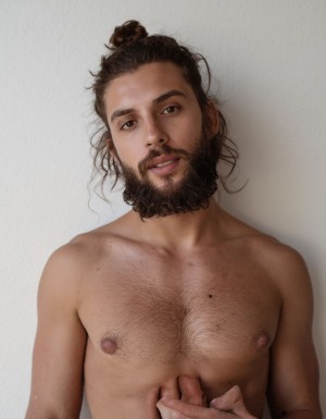 Hombre transgénero, hombre con vagina, hombre árabe con barba prolija, pelo largo atado con rodete, mucho vello corporal, completamente desnudo.